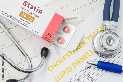 Effects and treatment of statins concept photo. Open packaging with drugs tablets, on which is written "Statin Medication", lies near stethoscope, result analysis on cholesterol (lipid panel) and ECG