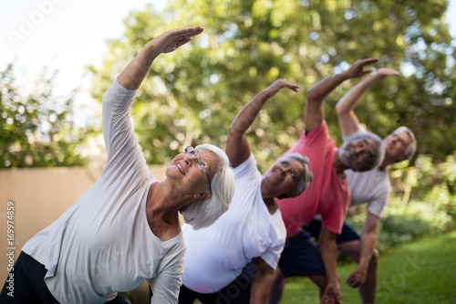 Senior people looking up while exercising with arms raised