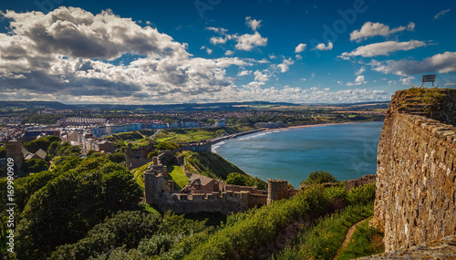 A wide angle shot of the Scarborough Castle, beach and old town in North Yorkshire, England, UK by sunset