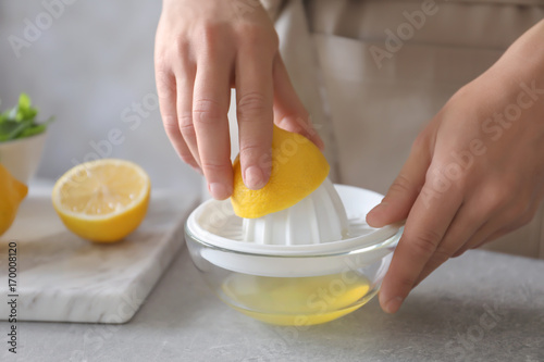 Man extracting lemon juice with plastic squeezer