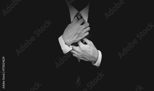 Businessman in black suit on black background, black and white