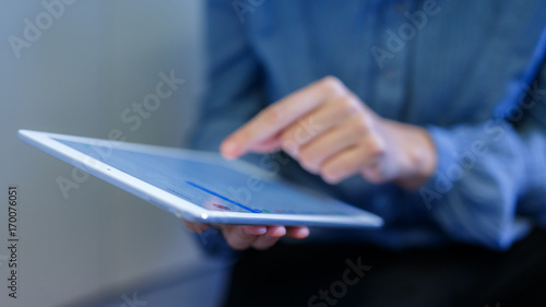 Frau zeigt auf Tablet in der Hand