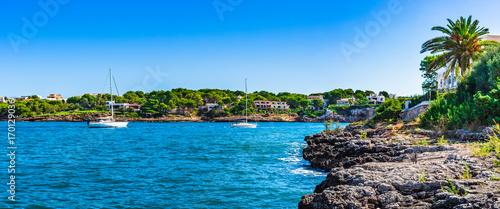 Beautiful seaside panorama with sailing boats at the bay coast of Portocolom on Majorca island, Spain