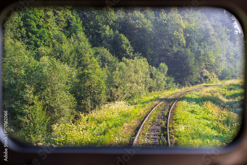 A view of the railway tracks through the train window. Horizontal frame