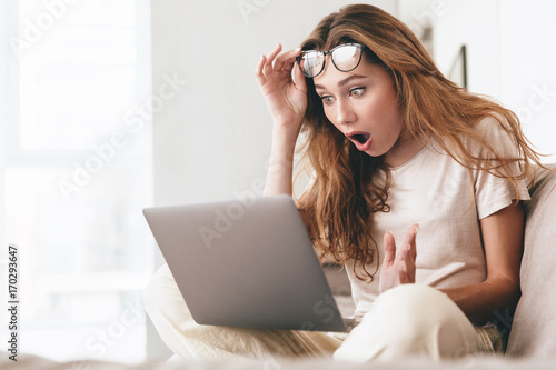 Shocked lady using laptop computer.