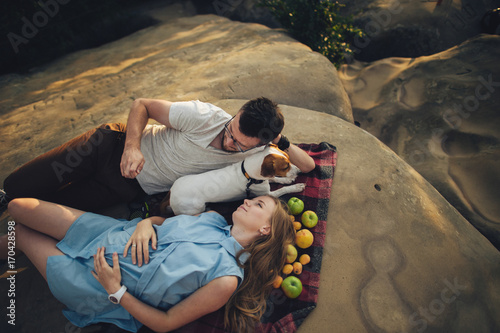 Happy young couple on picnic blanket. They are relaxing together on a summer day.