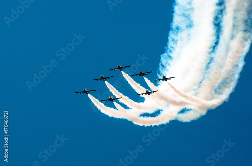 Fighter flies in the smoke in the blue sky aerobatics
