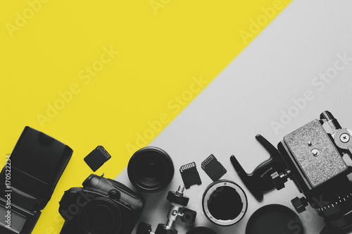 Digital camera, lenses and equipment of the photographer on a grey background