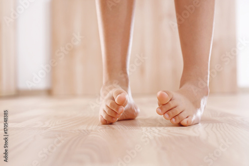 Zdrowa stopa dziecka. Dziecko bosymi stopami wykonuje ćwiczenia gimnastyki korekcyjnej.