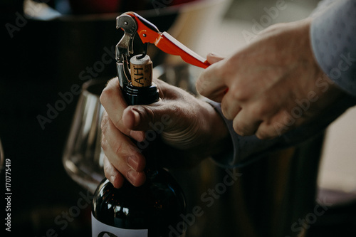 Sommelier opening wine bottle in the wine cellar