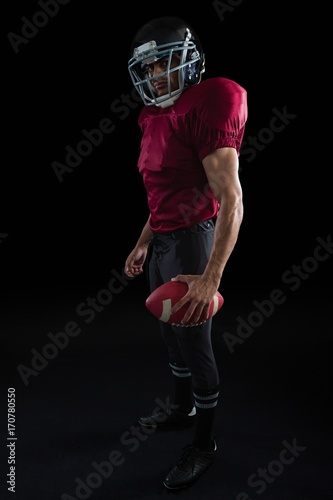 American football player holding a ball in one hand