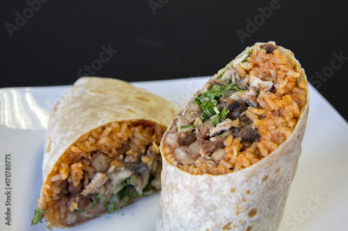 Two halves of a carne asada burrito on a plate