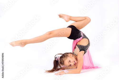 Flexible little girl gymnast doing acrobatic exercise on white background