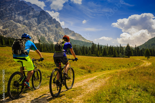 Mountain cycling couple with bikes on track, Cortina d'Ampezzo, Dolomites, Italy