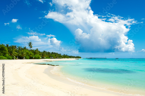 Beautiful sandy beach with sunbeds and umbrellas in Indian ocean, Maldives island