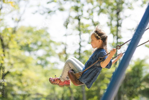 Little girl playing with a swing