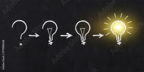 Black and white light bulb using doodle art on chalkboard background