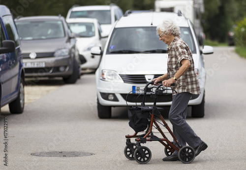 Seniorin am Rollator überquert die Straße