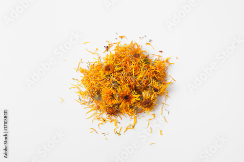 Dry calendula flowers pour a handful on white
