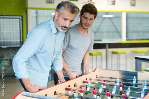 businesspeople playing table soccer game during their free time