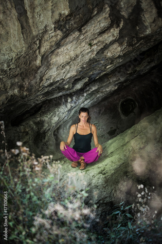 woman practice yoga meditation in small cave