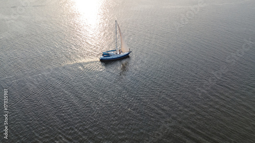 Aerial view of yacht sailing in Dnieper river on sunset from above 