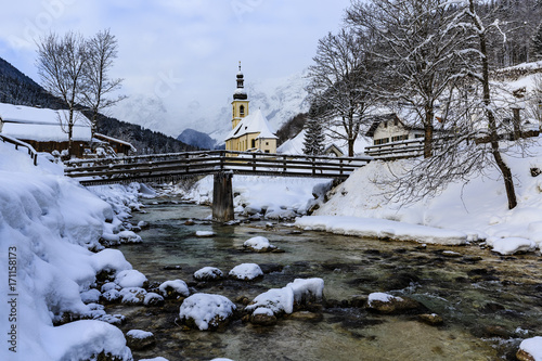 Panoramic view of winter river landscape in Ramsau, Bavarian Alps with famous Parish Church of St. Sebastian in the village of Ramsau, Nationalpark Berchtesgadener Land, Upper Bavaria, German