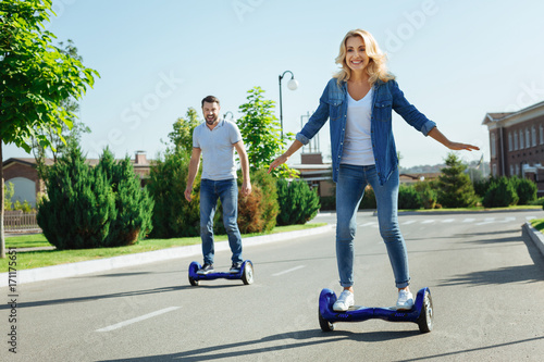 Happy husband and wife riding self-balancing scooters