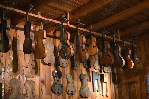 Violins hanging in luthier workshop
