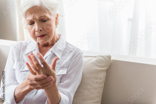 Elderly lady is enduring strong ache