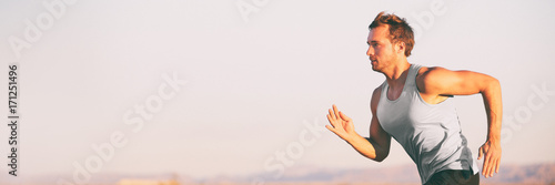 Fitness athlete runner man running on sunset sky background. Jogging active lifestyle concept.