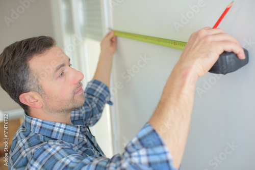 man with pencil measuring wall