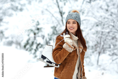 beautiful young woman with ice skates go to the rink