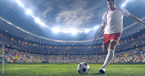 Piłkarz kopie piłkę na stadionie piłkarskim. Nosi niemarkową odzież sportową. Stadion i tłum wykonany w 3D.