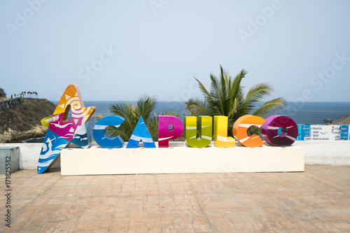 Colorful Acapulco inscription sign with bright colorful letters on a shoreline in summer sunny day