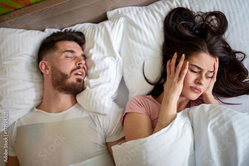 Women in bed with snoring husband