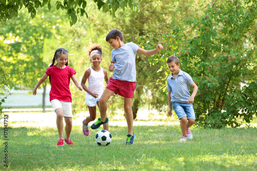 Cute children playing football in park