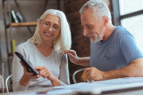 Positive aged couple purchasing online