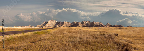 Panorama of badlands national park with vista of mountain range with large clouds in background