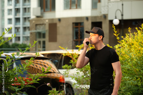 Male security guard with portable radio, outdoors