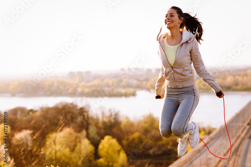 Active woman jumping with skipping rope outdoors