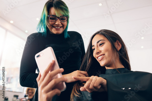 Women at salon looking at mobile phone