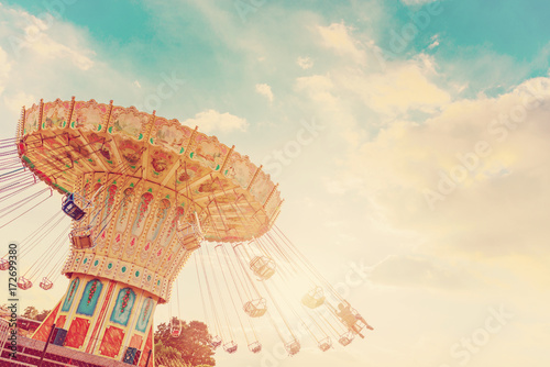 carousel ride spins fast in the air at sunset - vintage filter effects - a swinging carousel fair ride at dusk