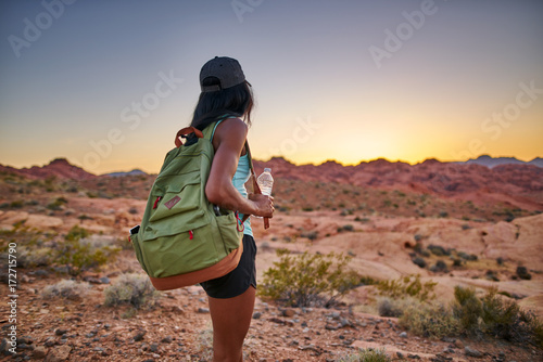 female african american hiker watching sunset in nevada desert at valley of fire