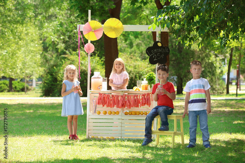 Happy children near lemonade stand in park