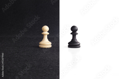 Pair of peon chess peaces confronted as opposites in black and white background