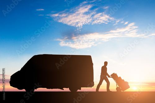 Silhouette Of Delivery Courier With Cardboard Boxes On Trolley