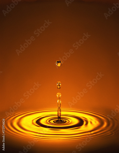 Droplet with ripples in orange red liquid