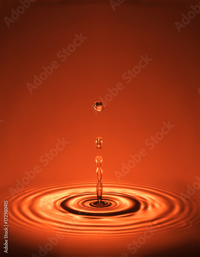 Droplet with ripples in red liquid