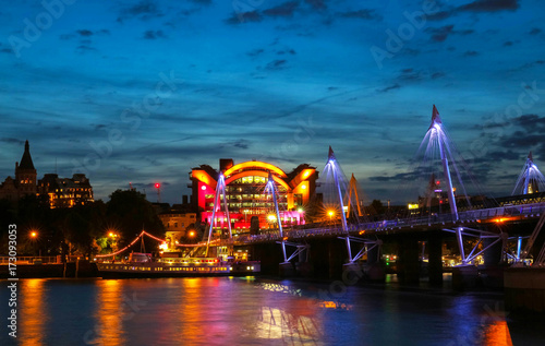 The Charing Cross station and Hungerford Bridge by the River Thames at night.